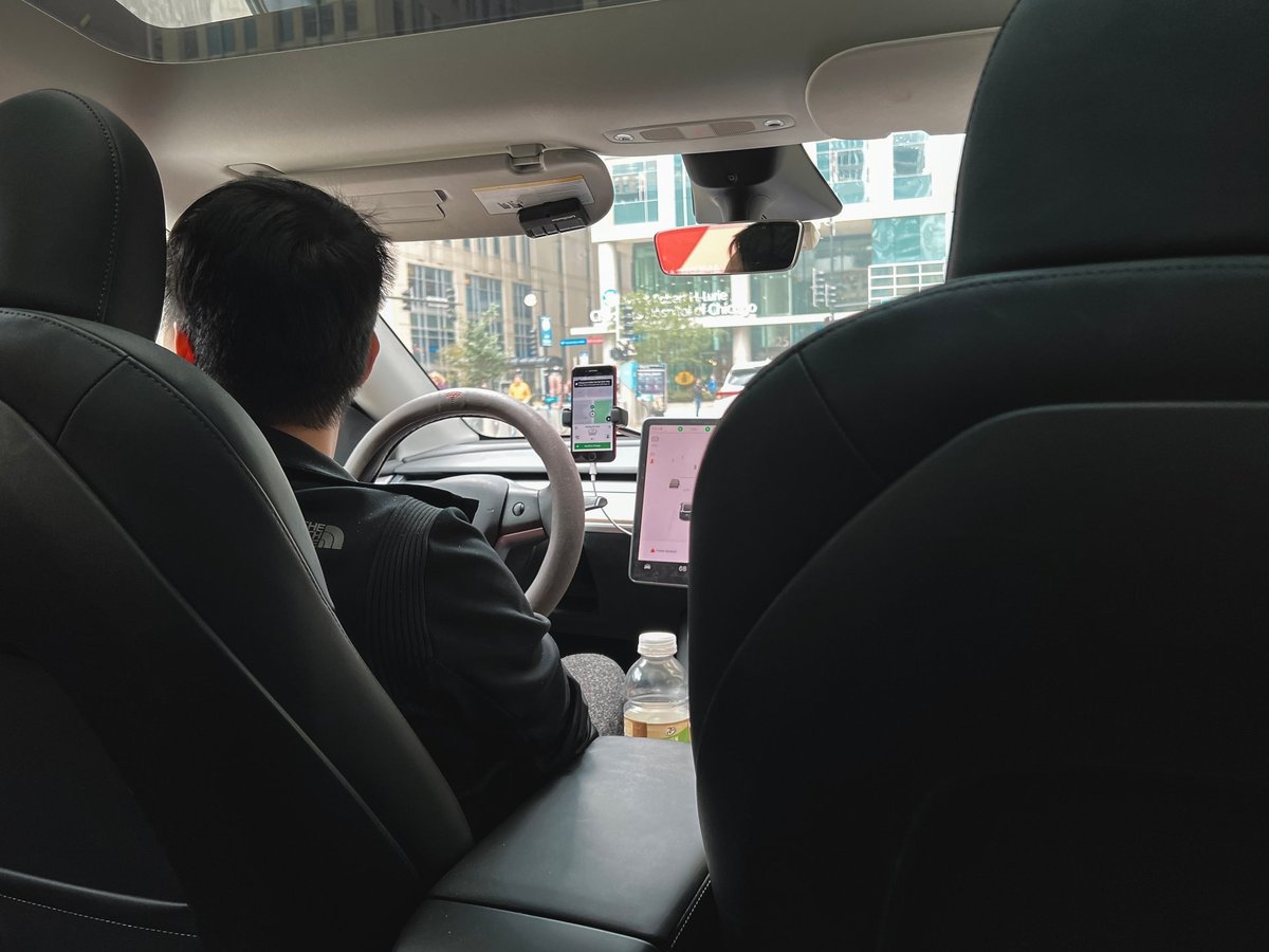 Rideshare driver behind the wheel of a modern car with a navigation device on the dashboard